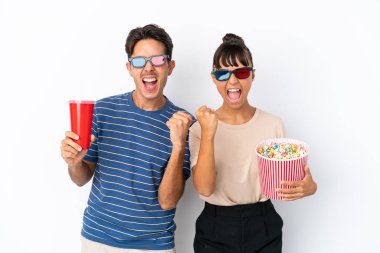 Beyaz arka planda 3 boyutlu gözlüklü ve elinde patlamış mısırla genç melez arkadaşlar.