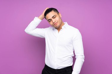 Asyalı yakışıklı adam mavi arka planda izole edilmiş. Kafasını kaşırken şüpheleri var.