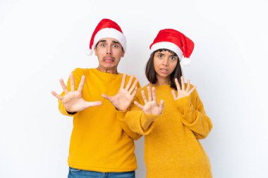 Genç melez çift Noel 'i beyaz arka planda yalnız kutluyor. Biraz gergin ve korkmuş eller öne doğru uzanıyor.
