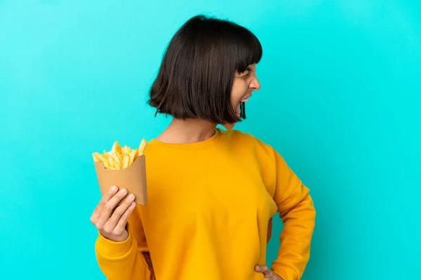 Fiatal Barna Kezében Sült Chips Felett Elszigetelt Kék Háttér Nevet — Stock Fotó