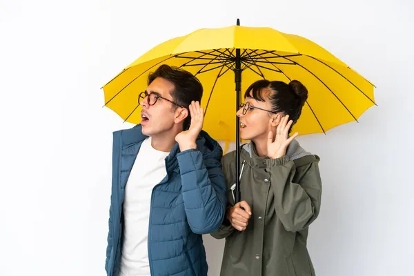 Junges Gemischtes Paar Hält Einen Regenschirm Auf Weißem Hintergrund Und — Stockfoto