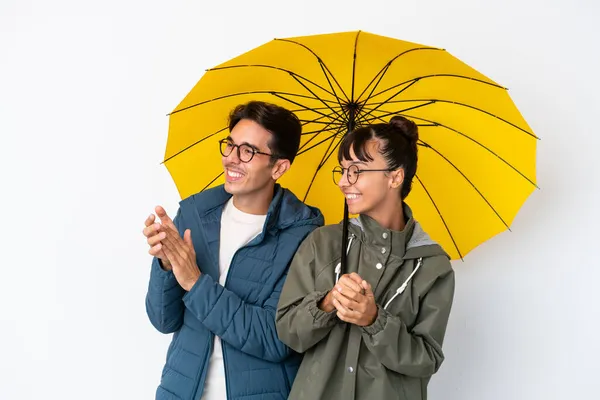 Junges Gemischtes Paar Mit Einem Regenschirm Auf Weißem Hintergrund Applaudiert — Stockfoto