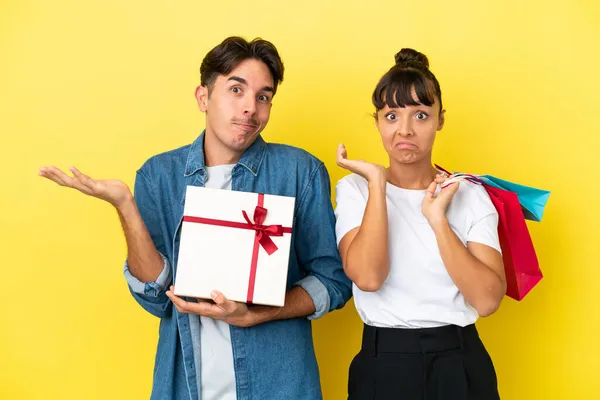 Casal Jovem Segurando Sacos Compras Presente Isolado Fundo Amarelo Com — Fotografia de Stock