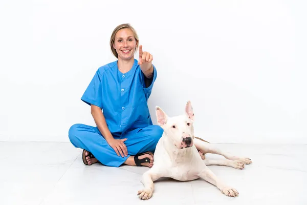Молодая Ветеринар Английская Женщина Сидит Полу Собакой Удивлен Указывая Фронт — стоковое фото