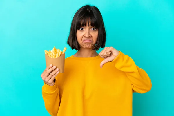 Joven Morena Sosteniendo Chips Fritos Sobre Fondo Azul Aislado Mostrando — Foto de Stock