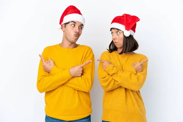 Jong Gemengd Ras Paar Vieren Kerstmis Geïsoleerd Witte Achtergrond Wijzend — Stockfoto