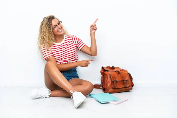 Giovane Studentessa Seduta Uno Pavimento Puntando Dito Verso Lato Presentando — Foto Stock