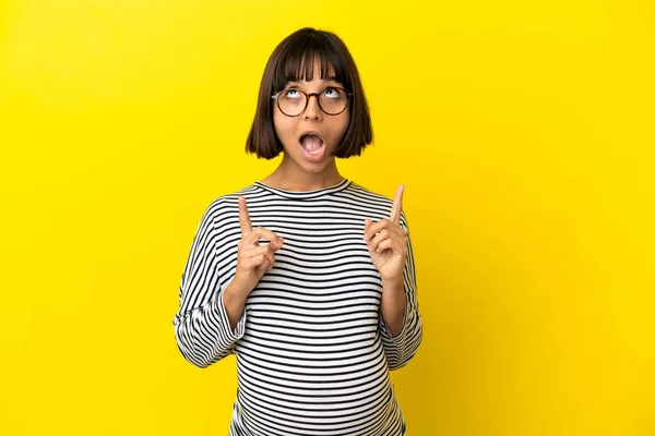 Giovane Donna Incinta Isolato Sfondo Giallo Sorpreso Indicando — Foto Stock