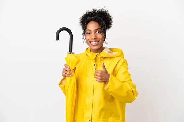 무지개 코트와 우산을 여자가 배경에 고립되어 엄지손가락을 치켜들고 — 스톡 사진