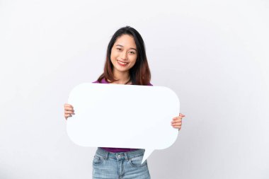 Beyaz arka planda izole edilmiş genç Vietnamlı kadın boş bir konuşma balonu tutuyor.