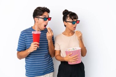 Beyaz arka planda 3 boyutlu gözlüklü ve elinde koca bir kova patlamış mısırla gezen melez arkadaşlar.