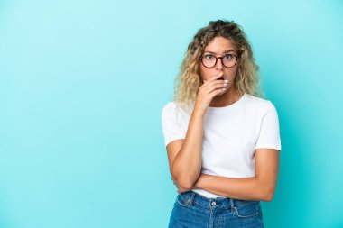 Mavi arka plandaki kıvırcık saçlı kız sağa bakarken şaşırmış ve şok olmuştu.