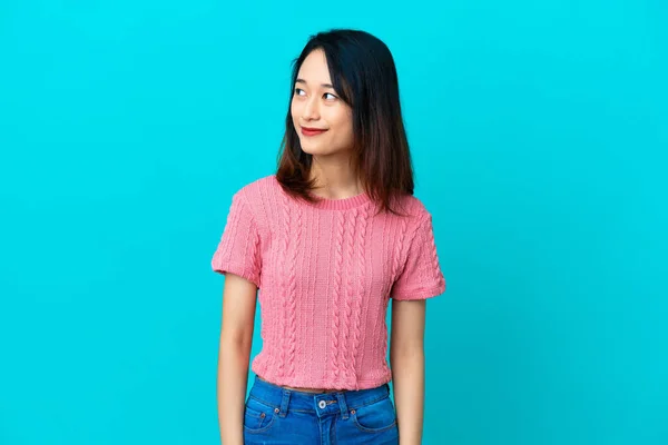 Ung Vietnamesisk Kvinna Isolerad Blå Bakgrund Tittar Sidan — Stockfoto