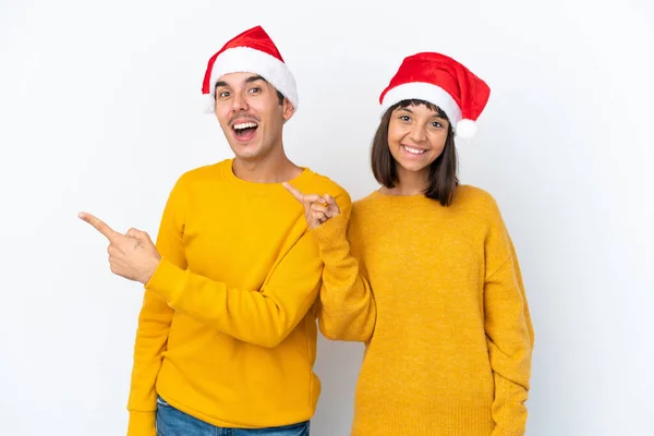 Jong Gemengd Ras Paar Vieren Kerstmis Geïsoleerd Witte Achtergrond Wijzend — Stockfoto