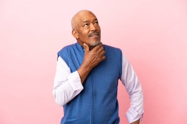 Kübalı son sınıf öğrencisi pembe arka planda izole edilmiş.