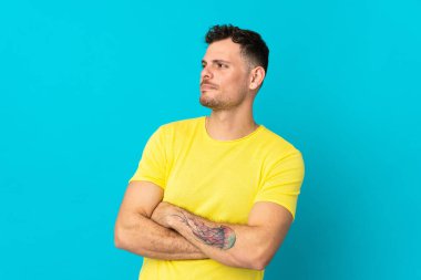 Beyaz tenli yakışıklı adam mavi arka planda izole edilmiş.