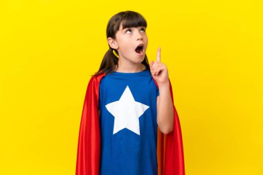 Mor arka planda izole edilmiş küçük süper kahraman çocuk bir fikir düşünüyor.