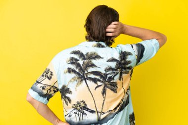 Hollandalı kıdemli adam sarı arka planda izole edilmiş ve düşünüyor.