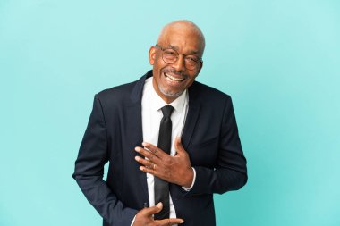 İşletme son sınıf öğrencisi mavi arka planda izole edilmiş, gülümsüyor.