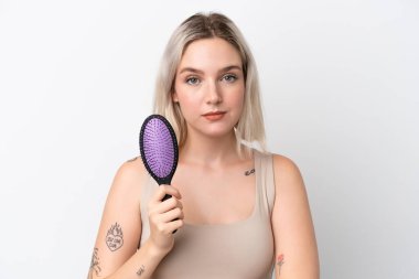 Beyaz arka planda saç tarağıyla izole edilmiş beyaz bir beyaz kadın.