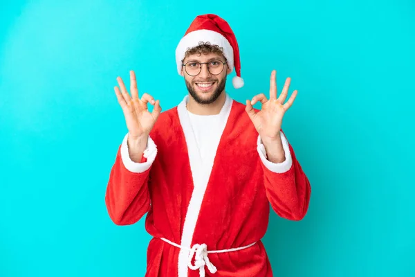Joven Disfrazado Santa Claus Aislado Sobre Fondo Azul Mostrando Signo —  Fotos de Stock