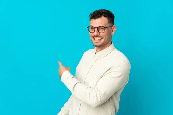 Jeune Homme Beau Caucasien Isolé Sur Fond Bleu Pointant Vers — Photo