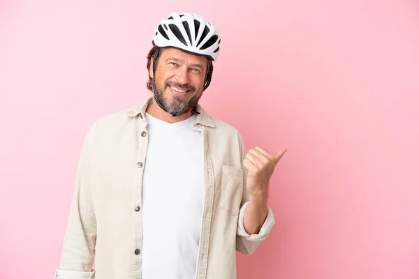 Старший Датчанин Велосипедным Шлемом Изолирован Розовом Фоне Указывая Сторону Представить — стоковое фото
