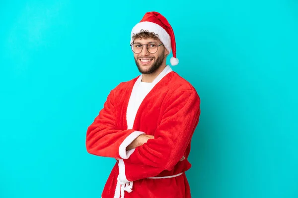 Ung Man Förklädd Till Jultomten Isolerad Blå Bakgrund Med Armarna — Stockfoto