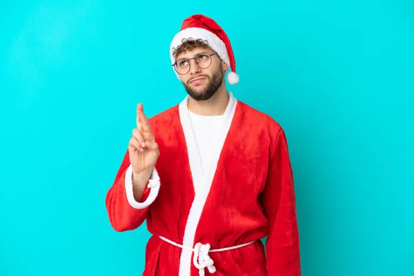 Junger Mann Verkleidet Als Weihnachtsmann Auf Blauem Hintergrund Mit Daumendrücken — Stockfoto