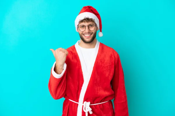 Joven Disfrazado Santa Claus Aislado Sobre Fondo Azul Apuntando Hacia — Foto de Stock