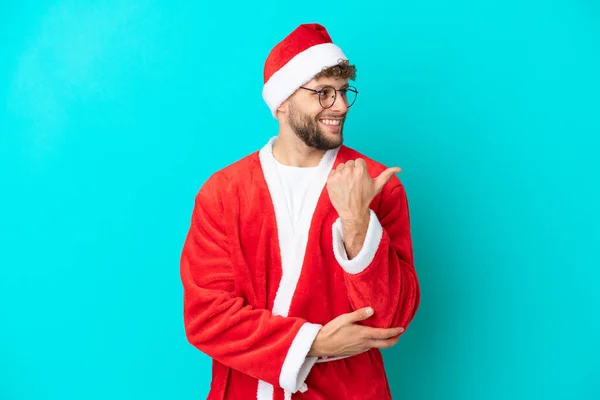 Joven Disfrazado Santa Claus Aislado Sobre Fondo Azul Apuntando Hacia —  Fotos de Stock
