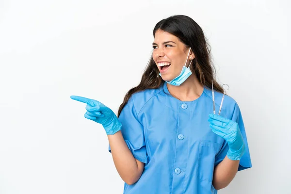 牙医妇女将工具放在孤立的白色背景上 手指指向侧面并展示产品 — 图库照片