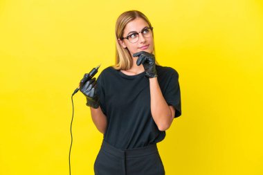 Dövme sanatçısı Uruguaylı kadın sarı arka planda izole edilmiş ve araştırılıyor