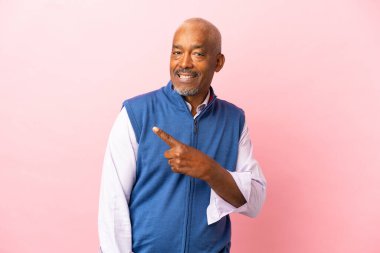 Kübalı son sınıf öğrencisi pembe arka planda izole edildi.