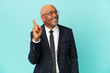 İşletme son sınıf öğrencisi mavi arka planda izole edildi. Çözümün farkına varmak için parmağını kaldırdı.