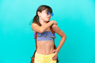 Küçük beyaz bir çocuk kumsala gidiyor. Mavi arka planda izole edilmiş. Omuz ağrısı çekiyor.