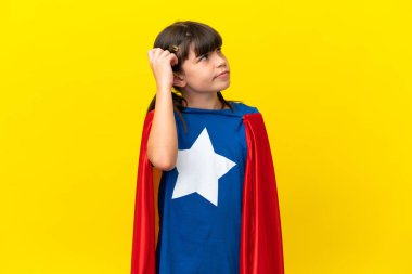 Mor arka planda izole edilmiş küçük süper kahraman çocuk. Şüpheleri var ve kafası karışmış bir yüz ifadesi var.