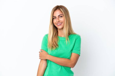 Sarışın Uruguaylı kız beyaz arka planda yalnız gülüyor.