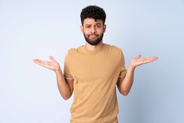 Faslı genç bir adam mavi arka planda izole edilmiş.