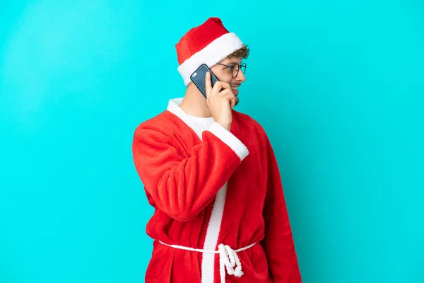 Joven Disfrazado Santa Claus Aislado Sobre Fondo Azul Manteniendo Una —  Fotos de Stock