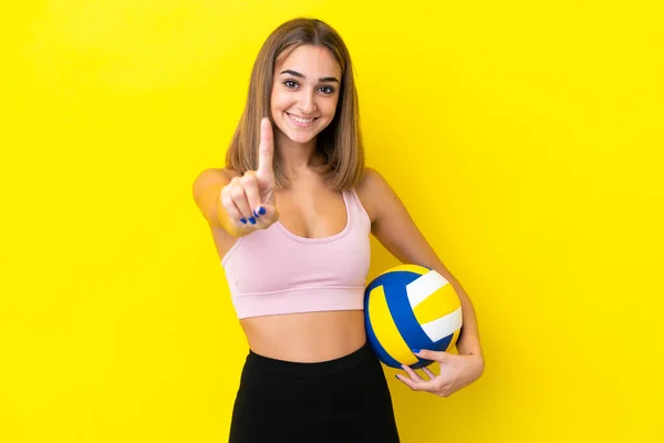 Sarı Arka Planda Izole Edilmiş Voleybol Oynayan Genç Kadın Parmağını — Stok fotoğraf