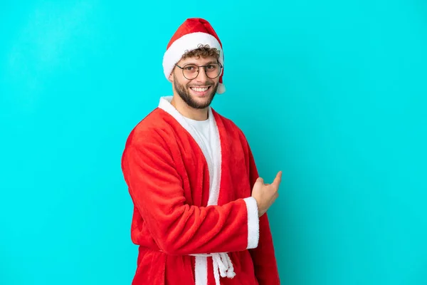 Joven Disfrazado Santa Claus Aislado Sobre Fondo Azul Apuntando Hacia — Foto de Stock