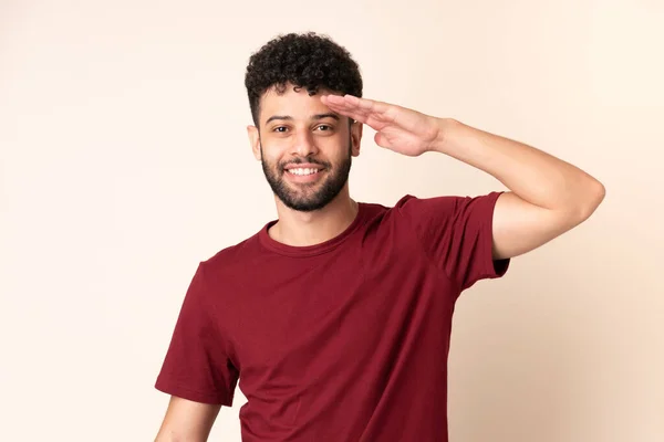 Young Moroccan Man Isolated Beige Background Saluting Hand Happy Expression — Stockfoto