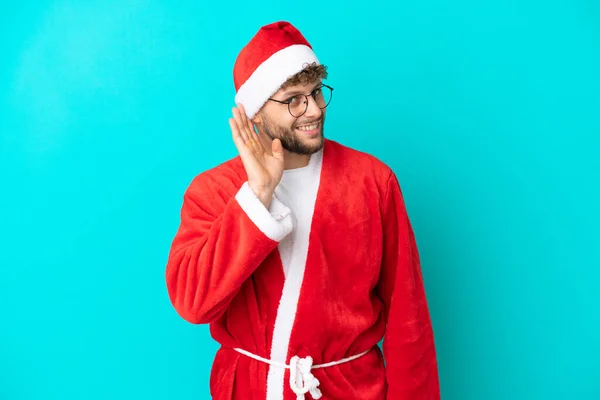 Joven Disfrazado Santa Claus Aislado Sobre Fondo Azul Escuchando Algo —  Fotos de Stock