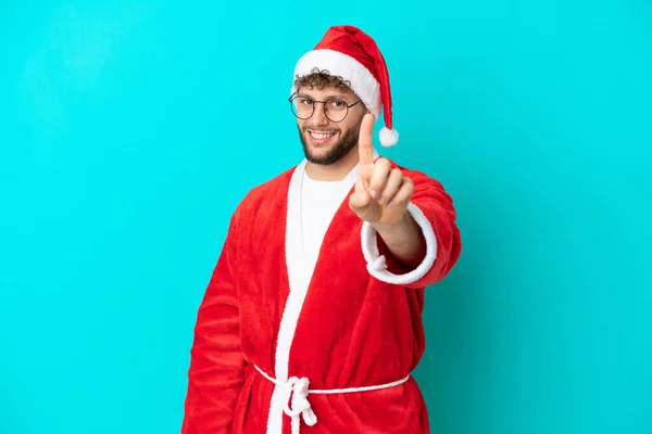 Jovem Disfarçado Papai Noel Isolado Fundo Azul Mostrando Levantando Dedo — Fotografia de Stock