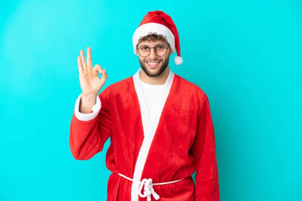 Junger Mann Verkleidet Als Weihnachtsmann Auf Blauem Hintergrund Zeigt Zeichen — Stockfoto