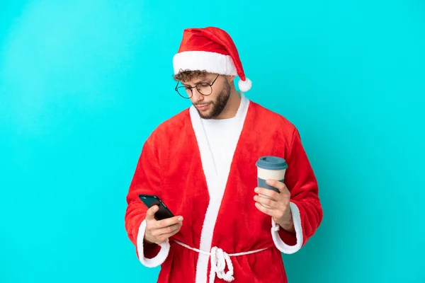 Молодой Человек Замаскированный Санта Клауса Изолированы Синем Фоне Держа Кофе — стоковое фото