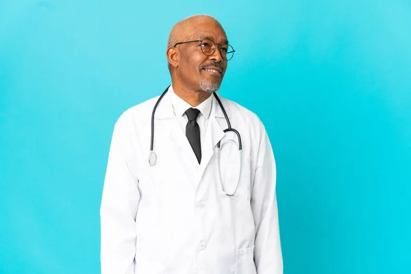 Anziano Medico Uomo Isolato Sfondo Blu Guardando Lato Sorridente — Foto Stock