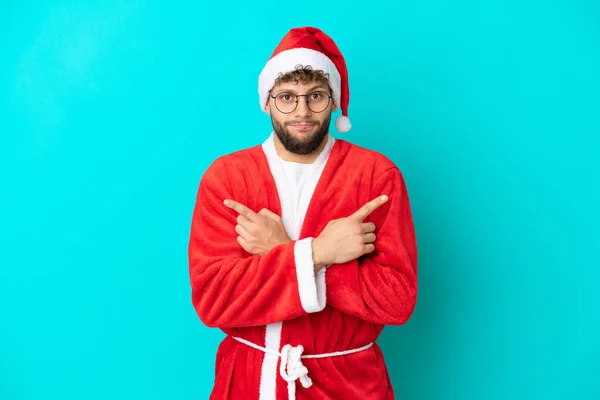 Joven Disfrazado Santa Claus Aislado Sobre Fondo Azul Apuntando Los —  Fotos de Stock