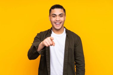 Asyalı yakışıklı adam sarı arka planda izole edilmiş. El kaldırırken şüpheleri var.